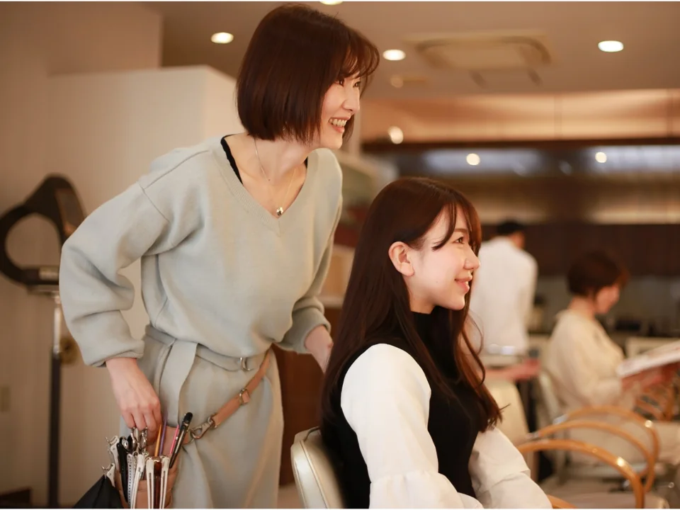 サロンで笑顔を見せる女性美容師とお客様